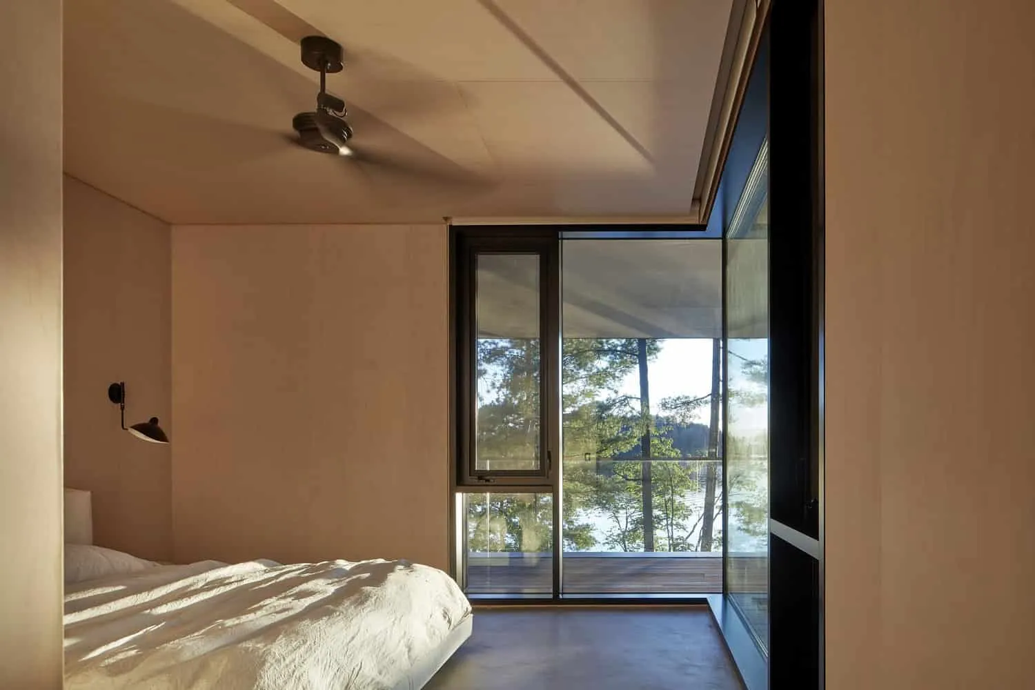 Bedroom with High Glass Windows Facing the Lake of Sagamore North Cottage by Akb Architects