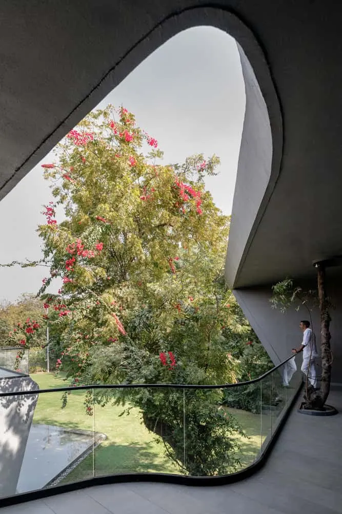 Curved balcony with garden view of House NINE X NINE in Gandhinagar