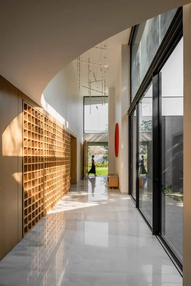 Gallery corridor with wooden latticed wall and high glazing in House NINE X NINE in Gandhinagar