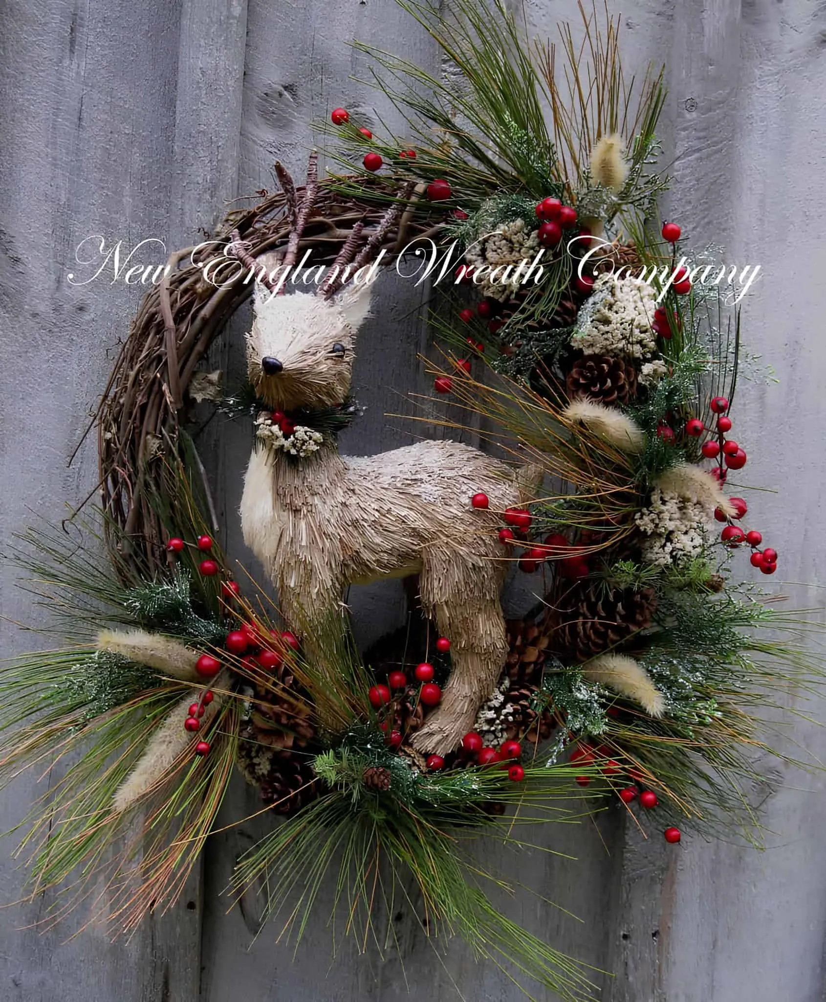 Waldrehe-Reben-Weihnachtskranz Holzfigur einer Waldrehe auf einem Rebenkranz mit roten Beeren, Kiefernnadeln und Zapfen