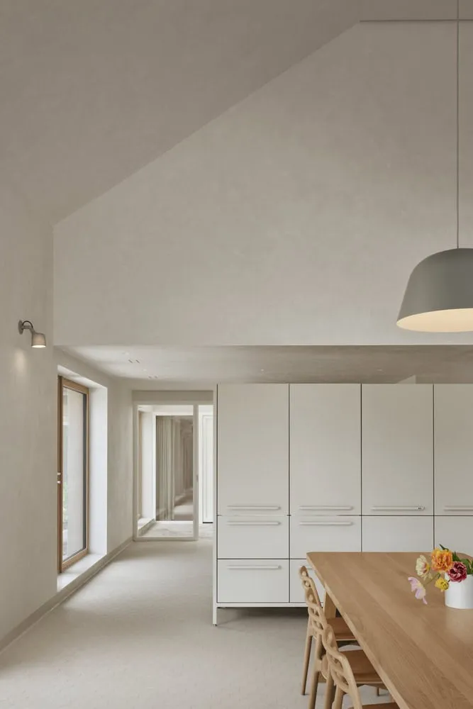 Maison Melba Kitchen Corridor Storage View by Atelier L’Abri Maison Melba von Atelier L’Abri mit Flur, der zur Küchenlagerung führt, sowie sanftem natürlichem Licht in Frelighsburg, Québec