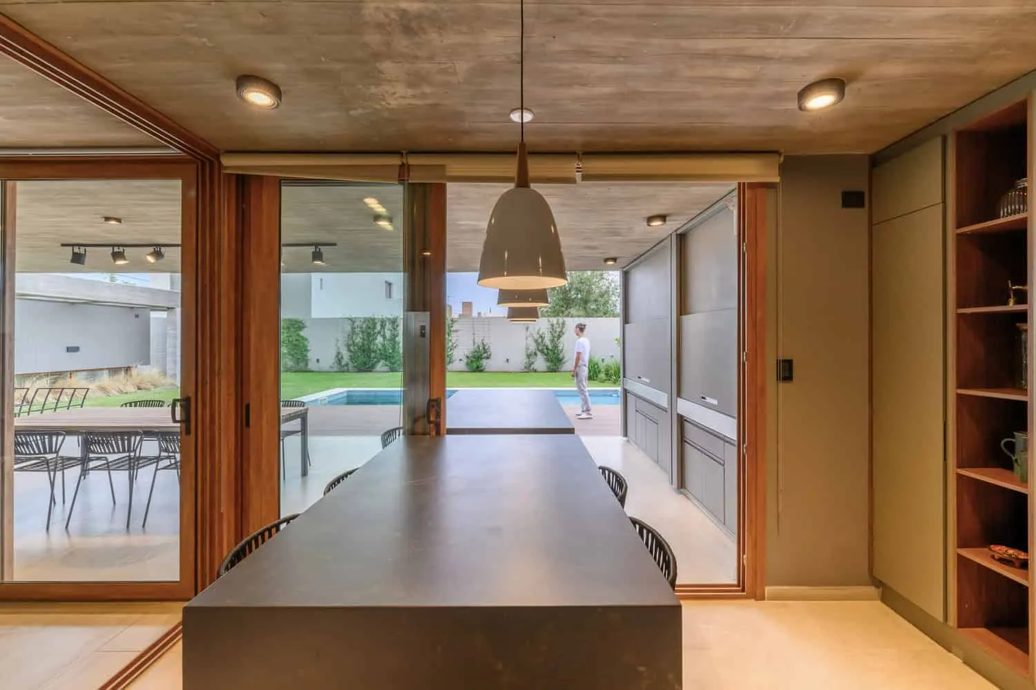 House G Kitchen Island Patio View by Karlen + Clemente House G von Karlen + Clemente – Kücheninsel mit Blick auf Patio und Pool, Río Tercero