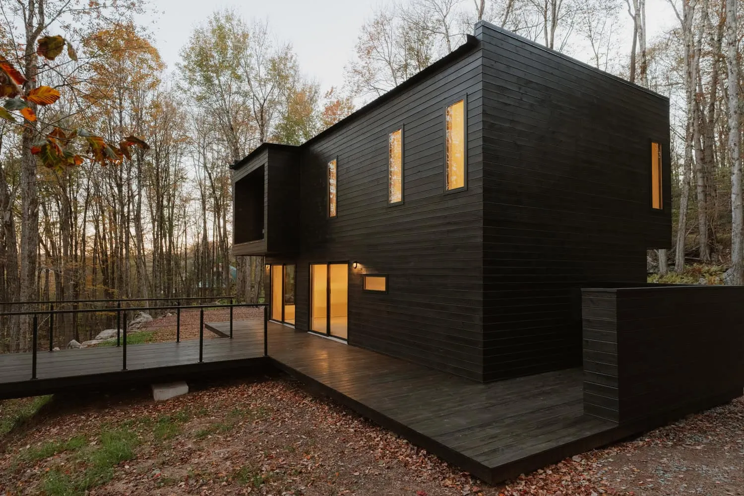 Rückansicht des Forest Edge House von Marc Thorpe Design Rückansicht des Forest Edge House mit schmalen Fenstern, die auf den Wald in New York blicken