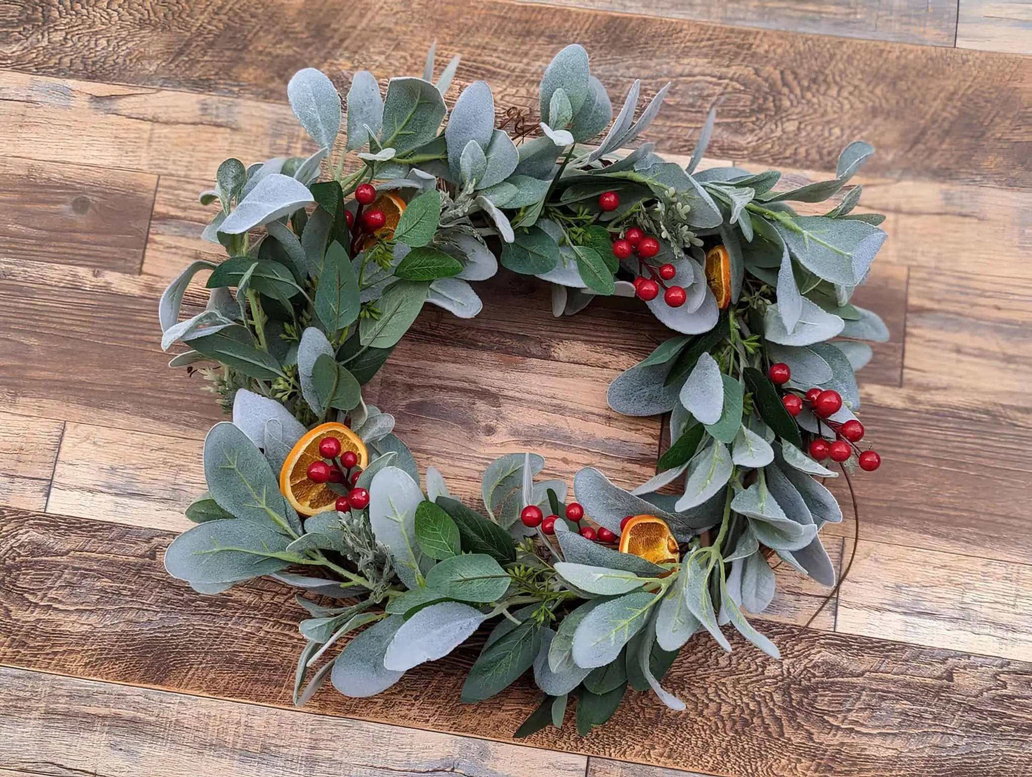 Weihnachtskranz mit Salbei-Eukalyptus und Orangenscheiben Weihnachtskranz mit Salbei-Eukalyptus, roten Beeren und getrockneten Orangenscheiben