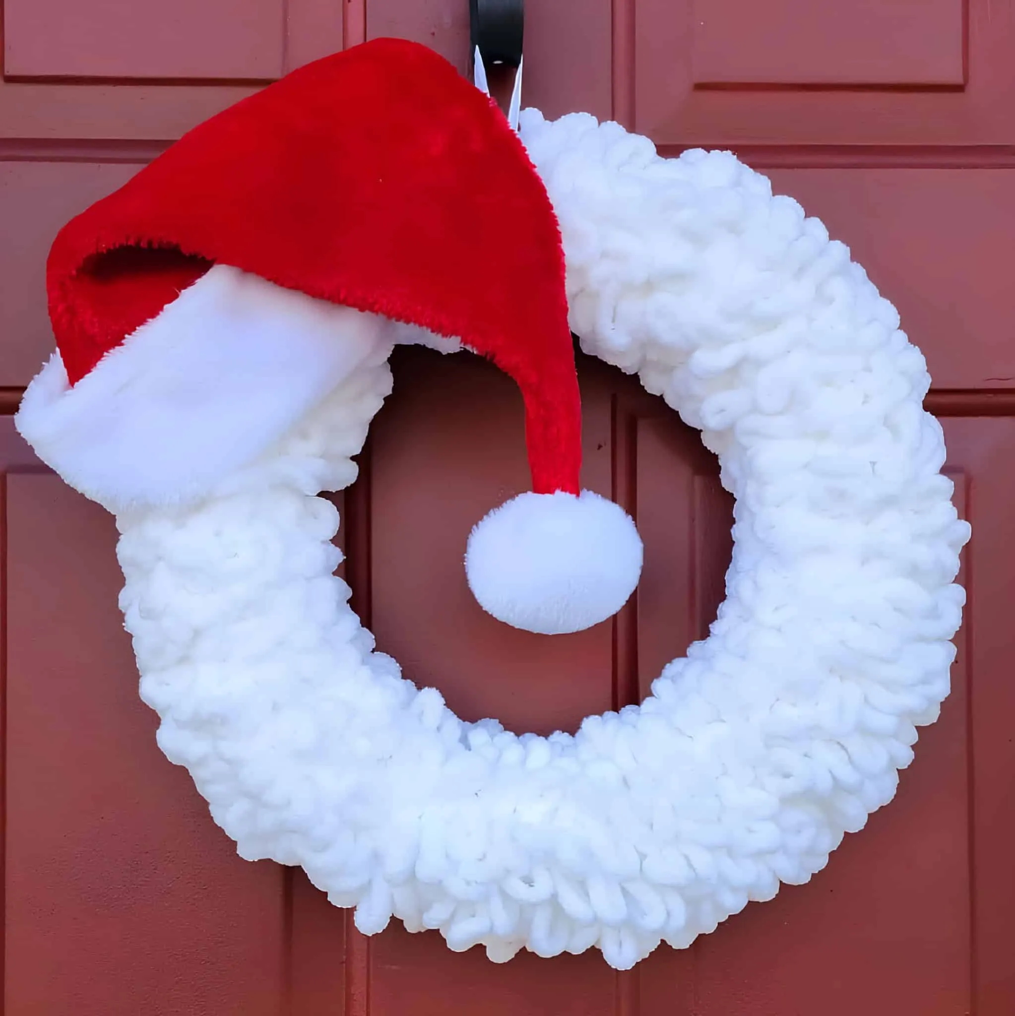 Fluffy Hat Santa Wreath Minimalistischer Weihnachtskranz mit weicher weißer Wolle und roter Santa-Mütze