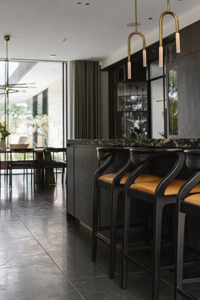 यूनाइटेड किंगडम के बकिंघमशायर में स्थित Weavers – Seer Green House का किचन बार, जिसमें Des Ewing Architects द्वारा डिज़ाइन की गई स्टूलें हैं