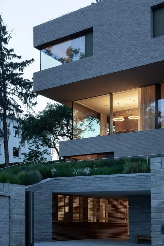 Gittervorhang am Eingang zur Garage in Villa Vista von Znameni Ctyr Architekti Eingang zur Garage im unteren Bereich von Villa Vista von Znameni Ctyr Architekti mit horizontaler Holzgittertür