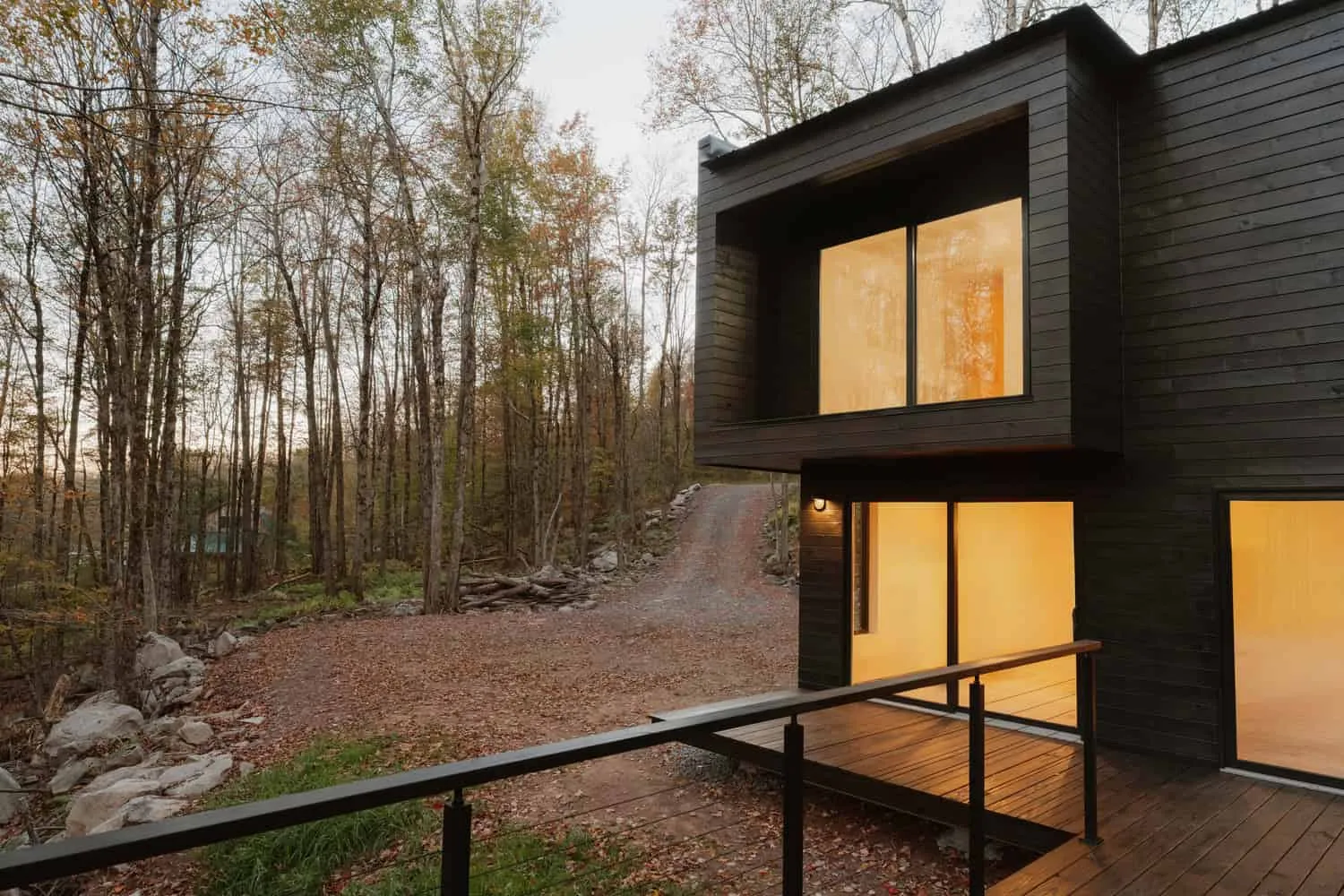 Terrasse und Eingang des Forest Edge House von Marc Thorpe Design Terrasse und verglaster Eingang des Forest Edge House mit Blick auf die Zufahrt und den Wald in New York