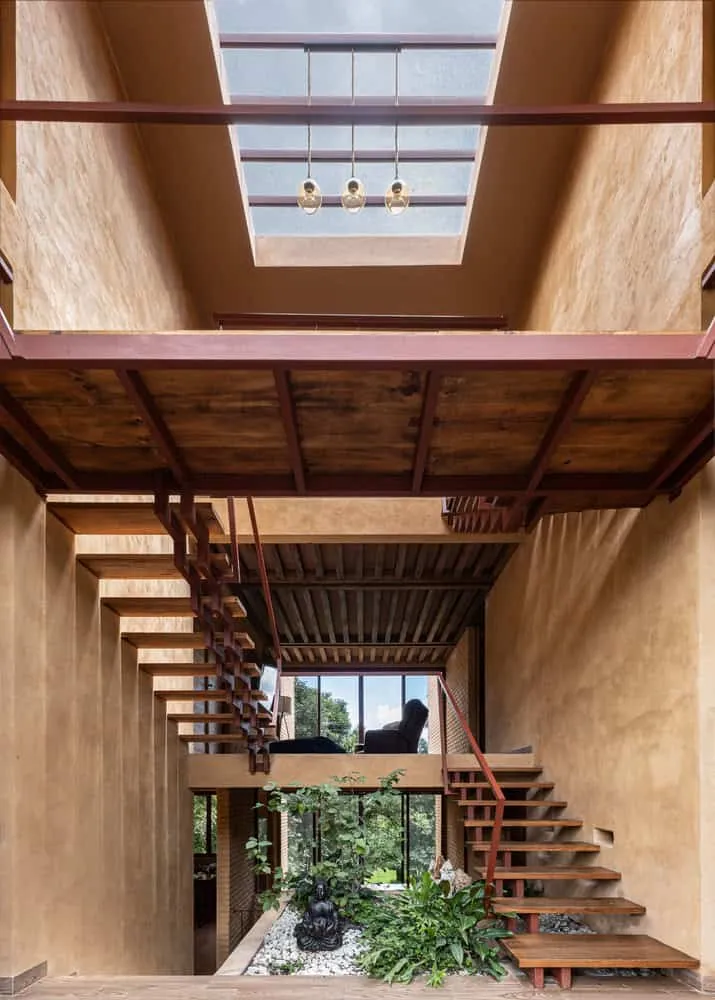 मेक्सिको के चियापास में Valdez Arquitectos द्वारा डिज़ाइन किया गया The Sierra House का केंद्रीय एत्रियम, जिसमें तैरती हुई सीढ़ियाँ, स्काईलाइट एवं इनडोर गार्डन है