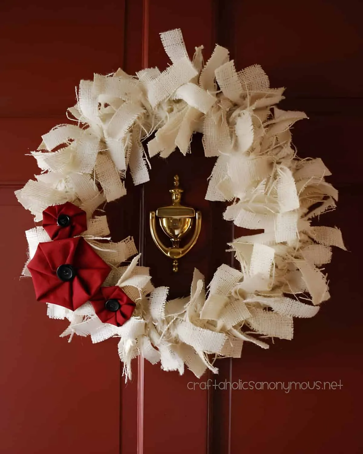 Weidenstoff- und rote Blumen-Weihnachtskranz Weihnachtskranz aus Weidenstoff mit roten Stoffblumen und schwarzen Knöpfen