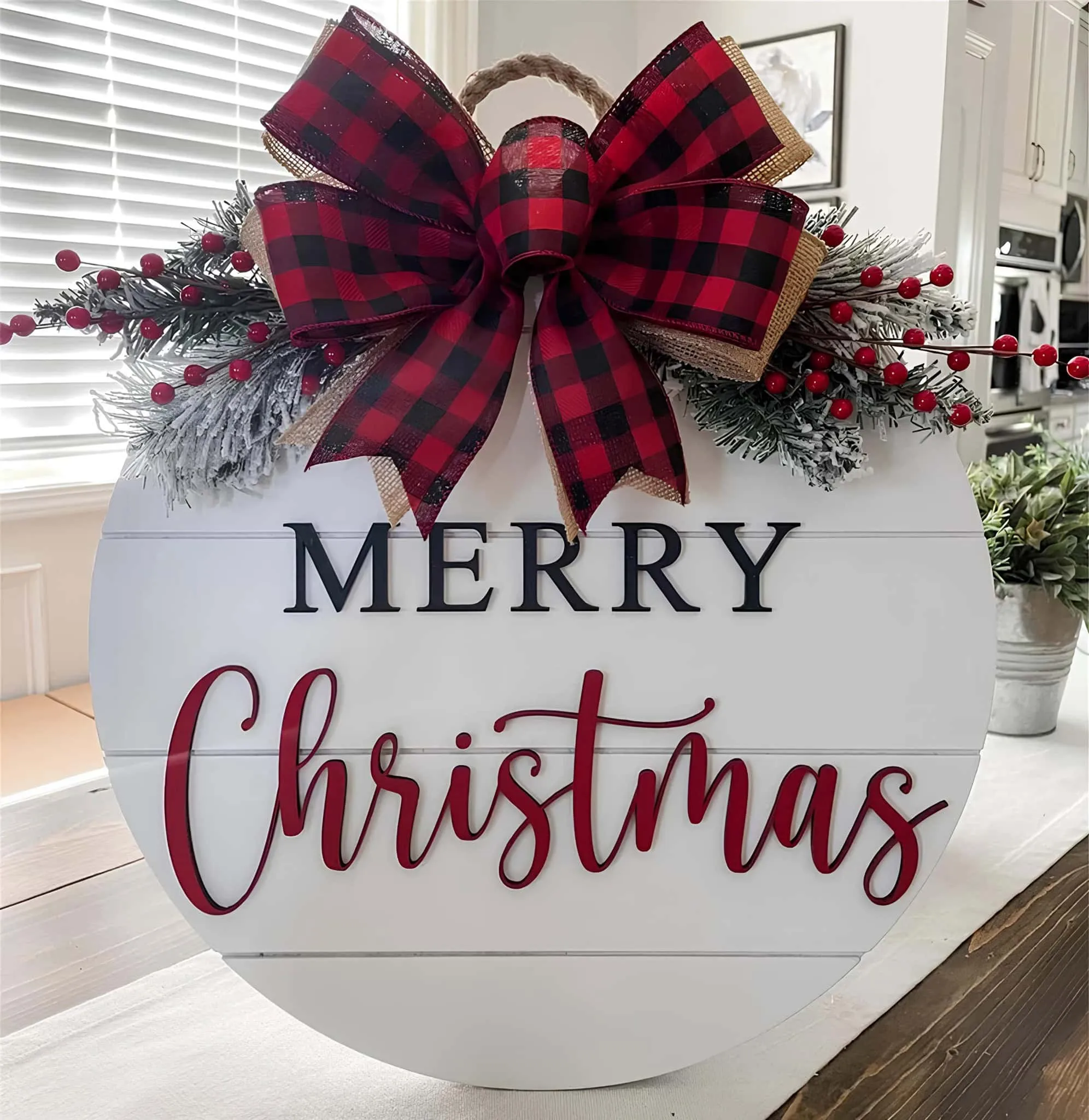 Runder Weihnachts-Schild mit Buffalo-Plaid-Binde Runder Weihnachts-Schild mit Buffalo-Plaid-Binde und getönter Grünpflanze