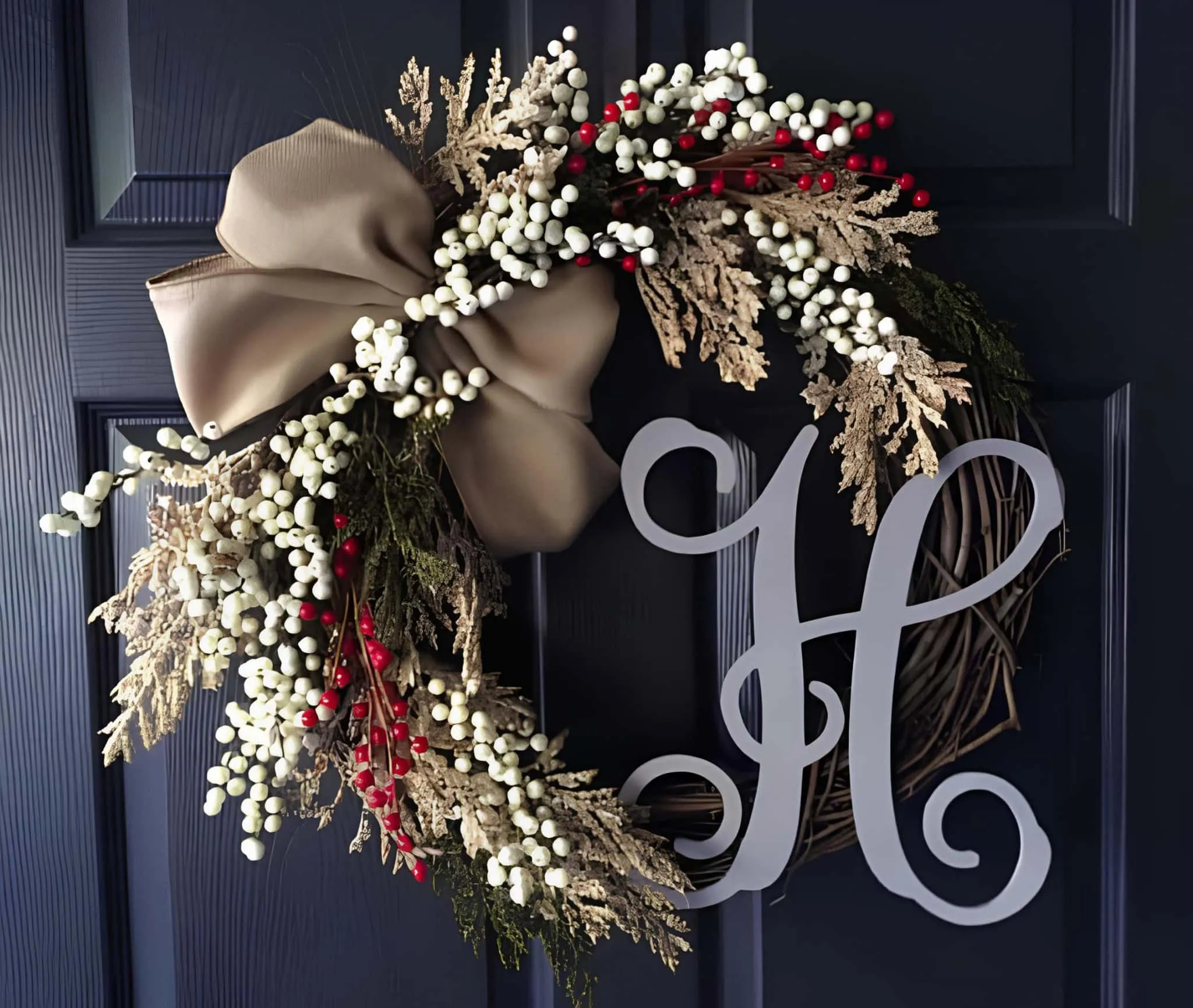 Weihnachtskranz mit Initial H, weißen Beeren und Schleife Eleganter Kranz mit einer großen taupefarbenen Schleife, weißen Beeren, zarten Blättern sowie der Initialen H in Schriftform