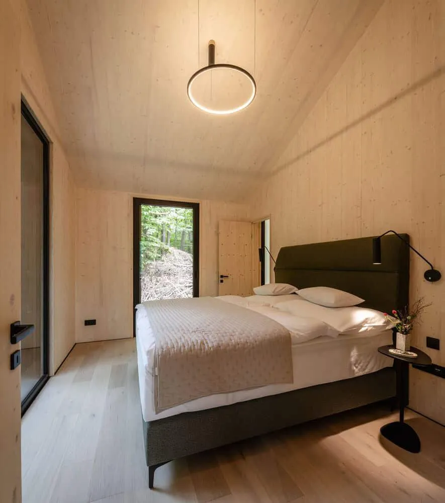 Monolith Lodge में लकड़ी की दीवारों वाला न्यूनतम डिज़ाइन वाला बेडरूम