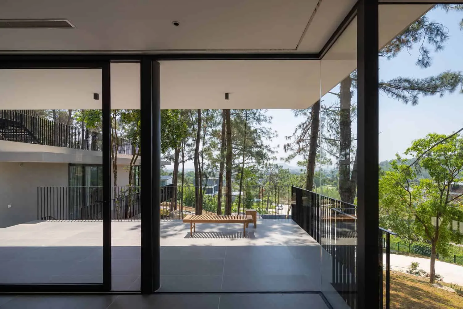 Tam Dao Retreat House covered terrace forest outlook by Idee architects Tam Dao Retreat House by Idee architects covered terrace with bench overlooking forest in Tam Dao, Vietnam