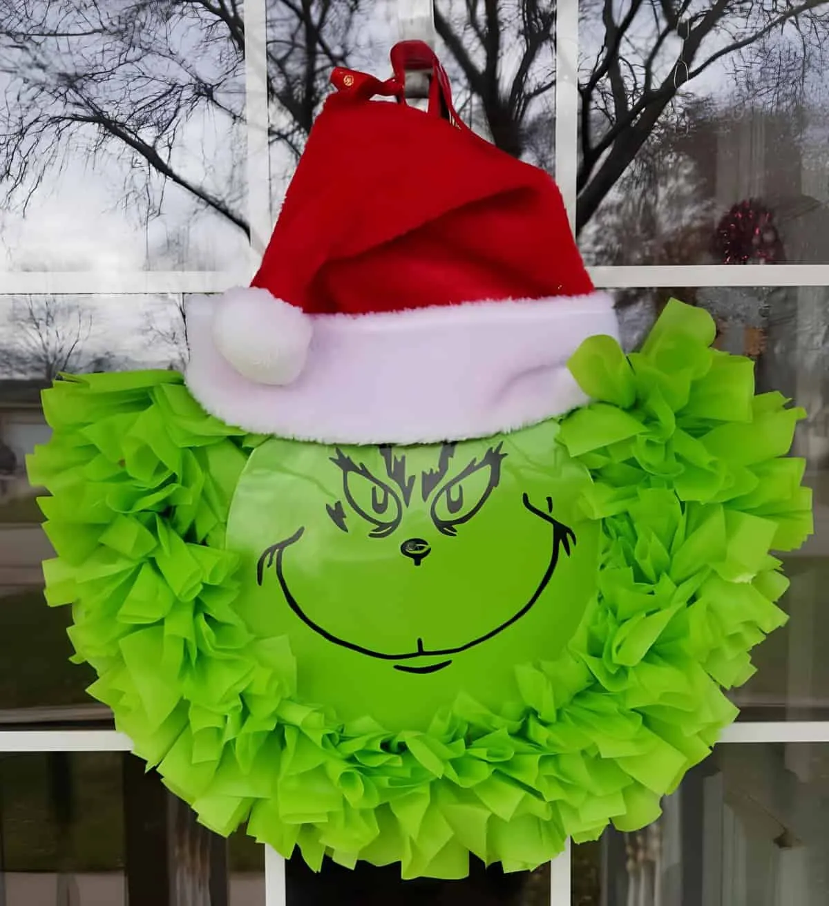 Grinch-Gesichts-Weihnachtskranz Grüner Grinch-Weihnachtskranz mit Santa-Mütze und Stoffrüschen