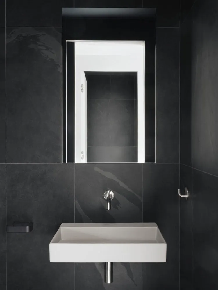 Maison Melba Minimalistisches Badezimmer mit schwarzen Fliesen von Atelier L’Abri Badezimmer von Maison Melba bei Atelier L’Abri mit schwarzen Fliesen und einem minimalistischen weißen Waschbecken in Frelighsburg, Quebec
