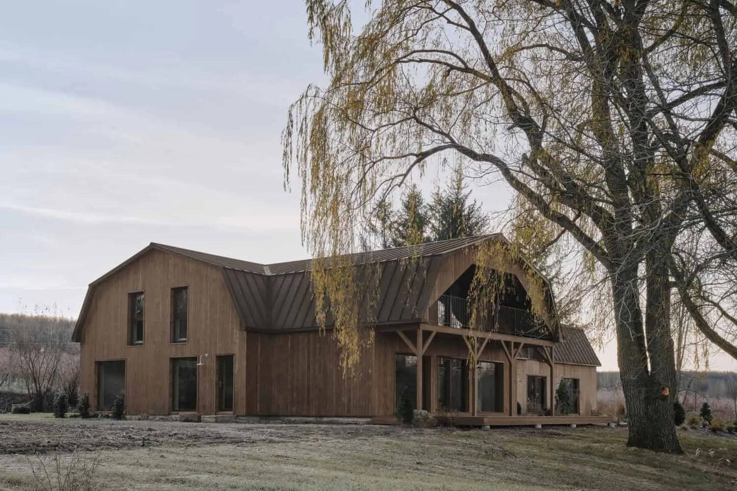Maison Melba Barn Porch Large Tree by Atelier L’Abri Maison Melba von Atelier L’Abri mit überdachtem Scheunenvorplatz und großem Baum im Vordergrund in Frelighsburg, Quebec