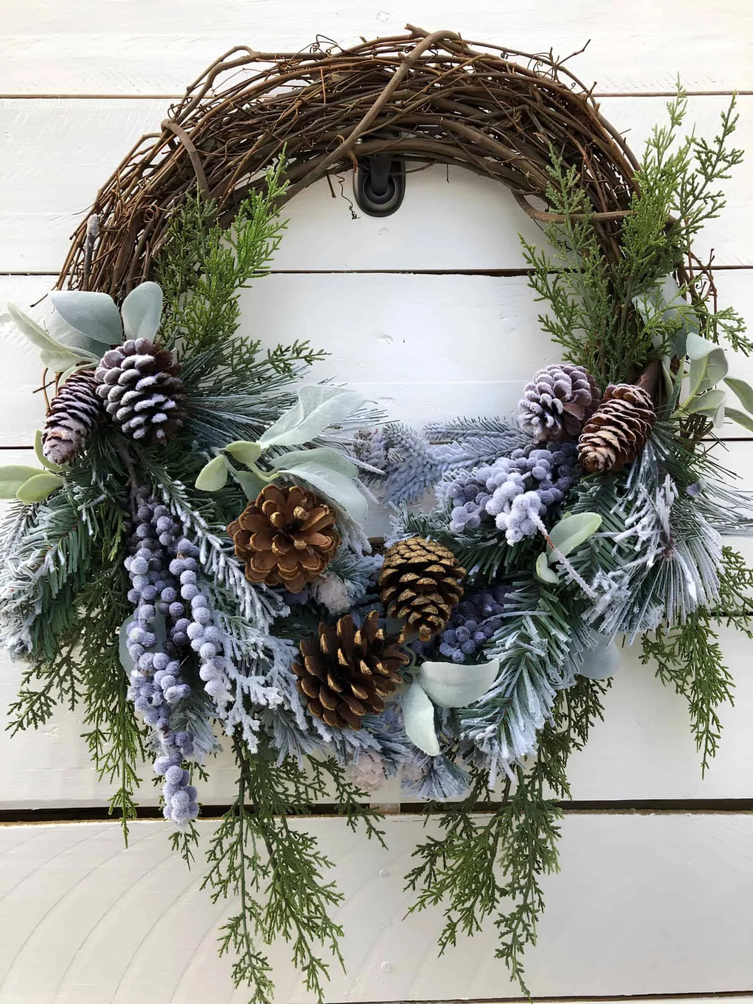 Gefrorener Kiefernzapfen- und immergrüner Holz-Weihnachtsgruß Gefrorener Winter-Kiefernzapfen-Weihnachtsgruß mit Kiefernzapfen, Eukalyptus und Grünpflanzen zur Dekoration des Ferienhauses.