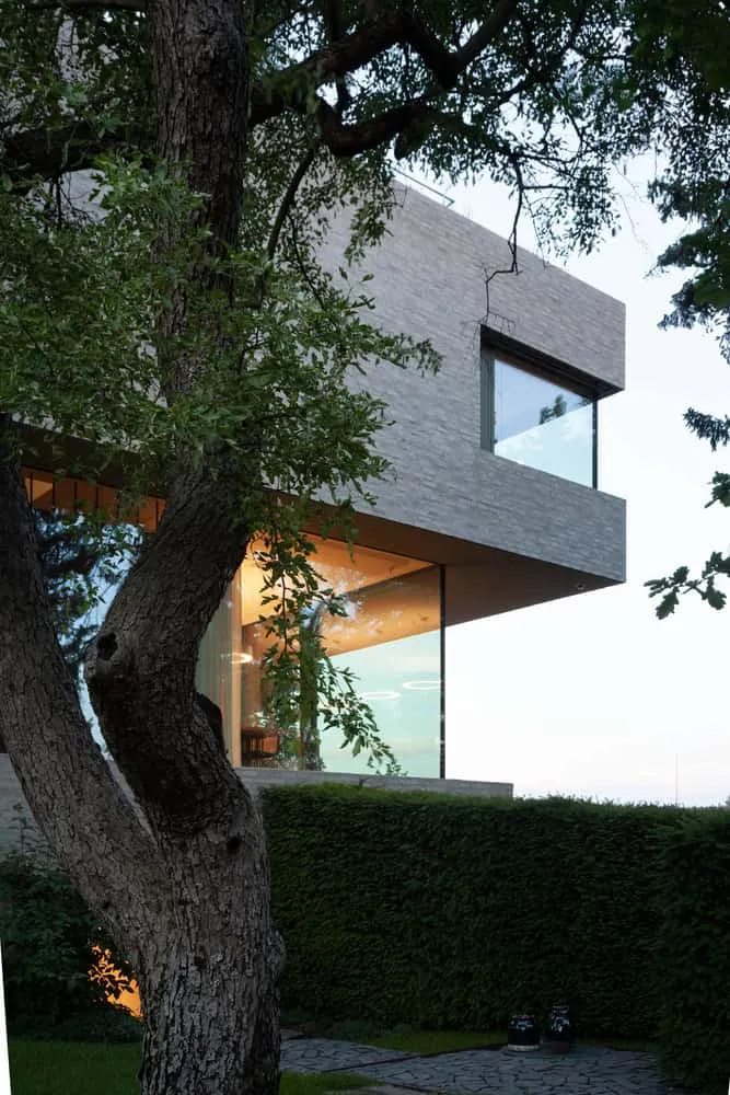Garten-Eck mit verglaster Wohnzone der Villa Vista von Znameni Ctyr Architekti Villa Vista von Znameni Ctyr Architekti, verglaster Wohnraum mit Ausblick auf den Garten in Prag
