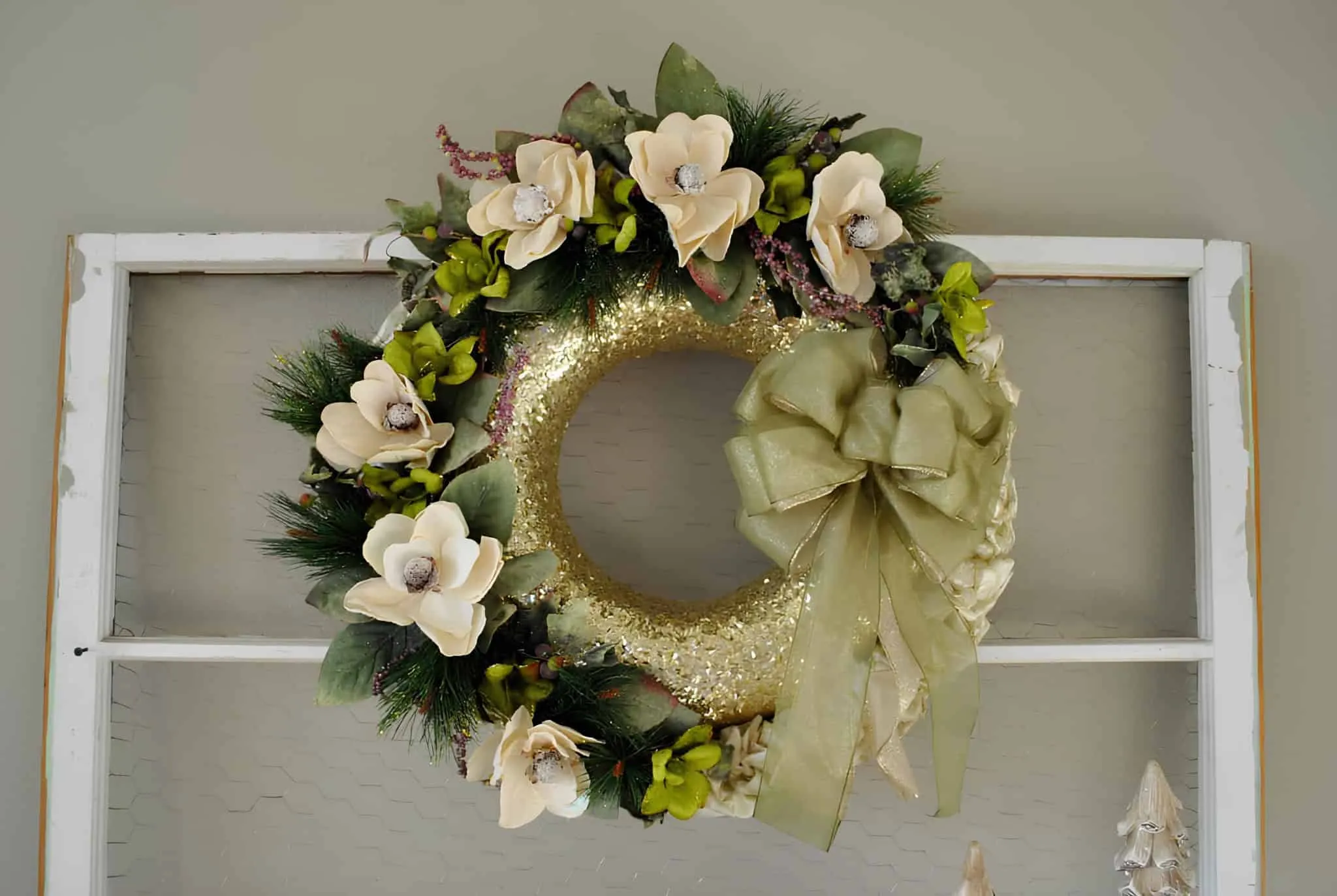 Goldener, glitzernder Blumen-Weihnachtskranz Goldener, glitzernder Weihnachtskranz, verziert mit cremefarbenen Blumen und grünem Band