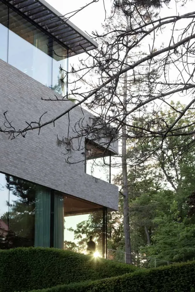Villa Vista – Fenster mit Sonnenscheineffekt in der Ecke von Znameni Ctyr Architekti Villa Vista von Znameni Ctyr Architekti, verglaste Ecke mit Sonnenscheineffekt sowie Silhouettengestalt im Fenster