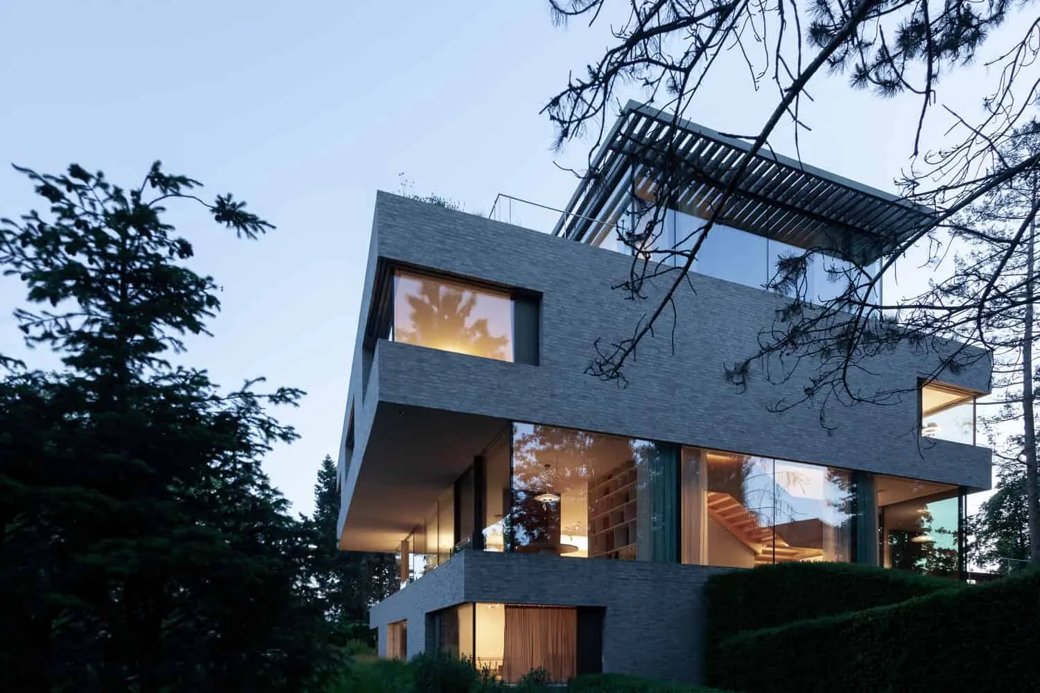 Fassade mit Gartenstufen der Villa Vista am Abend von Znameni Ctyr Architekti Villa Vista von Znameni Ctyr Architekti, abendliche Gartenfassade mit Außentreppen und großen Fenstern in Prag