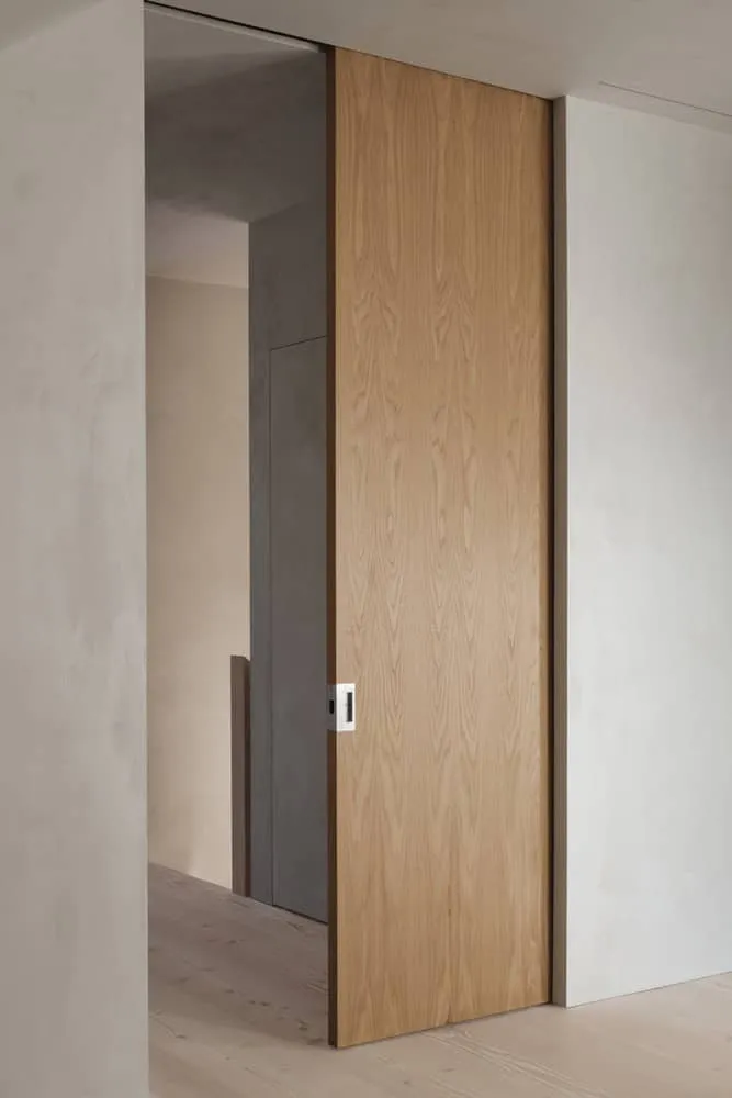 Detail der schwenkbaren Holztür in Maison Melba von Atelier L’Abri Innenraum von Maison Melba von Atelier L’Abri mit minimalistischer schwenkbare Holztür in Frelighsburg, Quebec