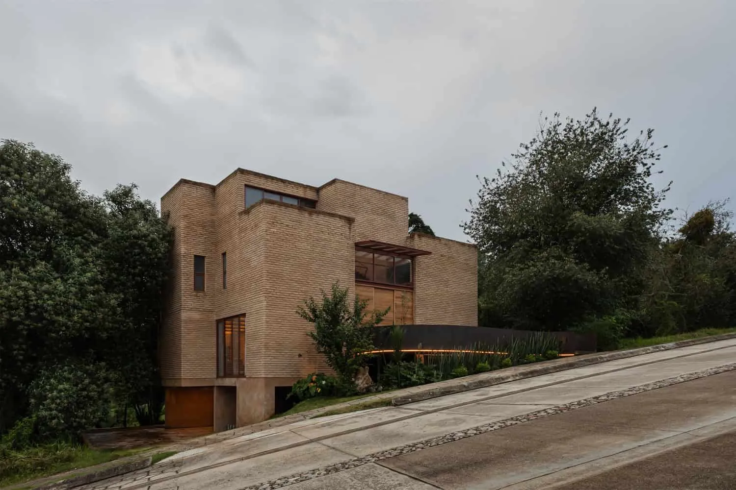 मेक्सिको के चियापास में एक तीव्र ढलान पर स्थित Valdez Arquitectos द्वारा डिज़ाइन किया गया The Sierra House की ईंटों से बनी मुख़र होने वाली इमारत