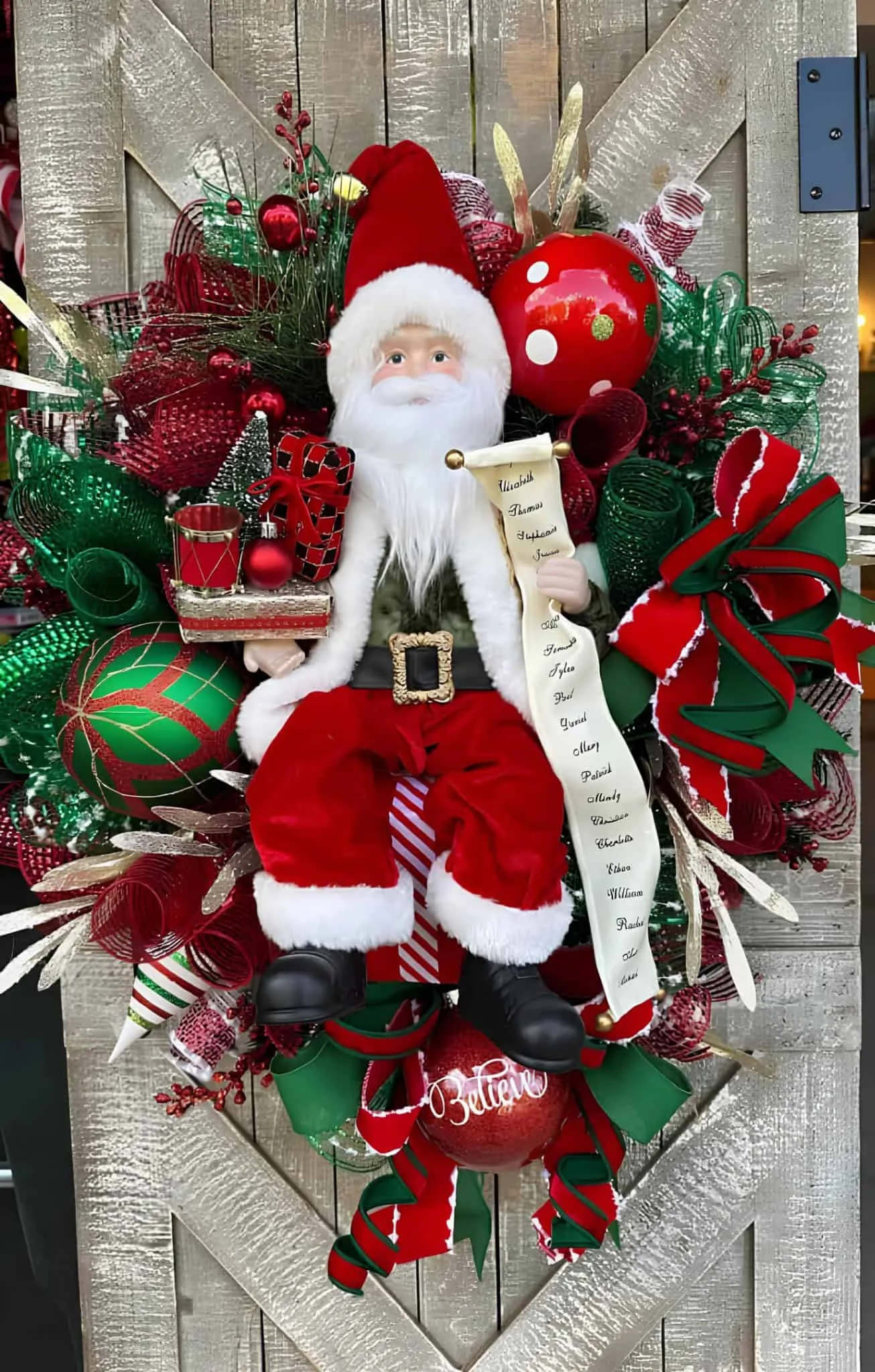 Kranz mit Weihnachtsmann-Geschenkeliste Festlicher Weihnachtsmann-Kranz mit Geschenkeliste, rotem und grünem Netz sowie Weihnachtsdekorationen