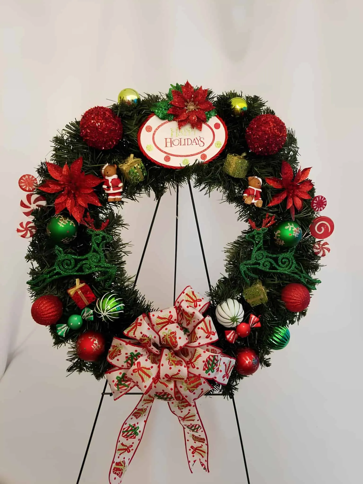 Candy Cane Holiday Ornament Wreath Festliche Weihnachtskrone mit roten und grünen Verzierungen, Poinsettien sowie einer gemusterten Schleife