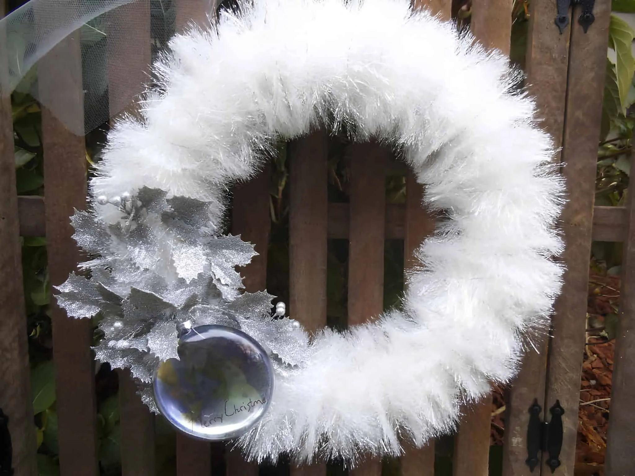 Weißer Weihnachtskranz mit Silberglitzer und Verzierung Weißer Weihnachtskranz mit Silberglitzer, silbernen Blättern und einer hängenden Verzierung