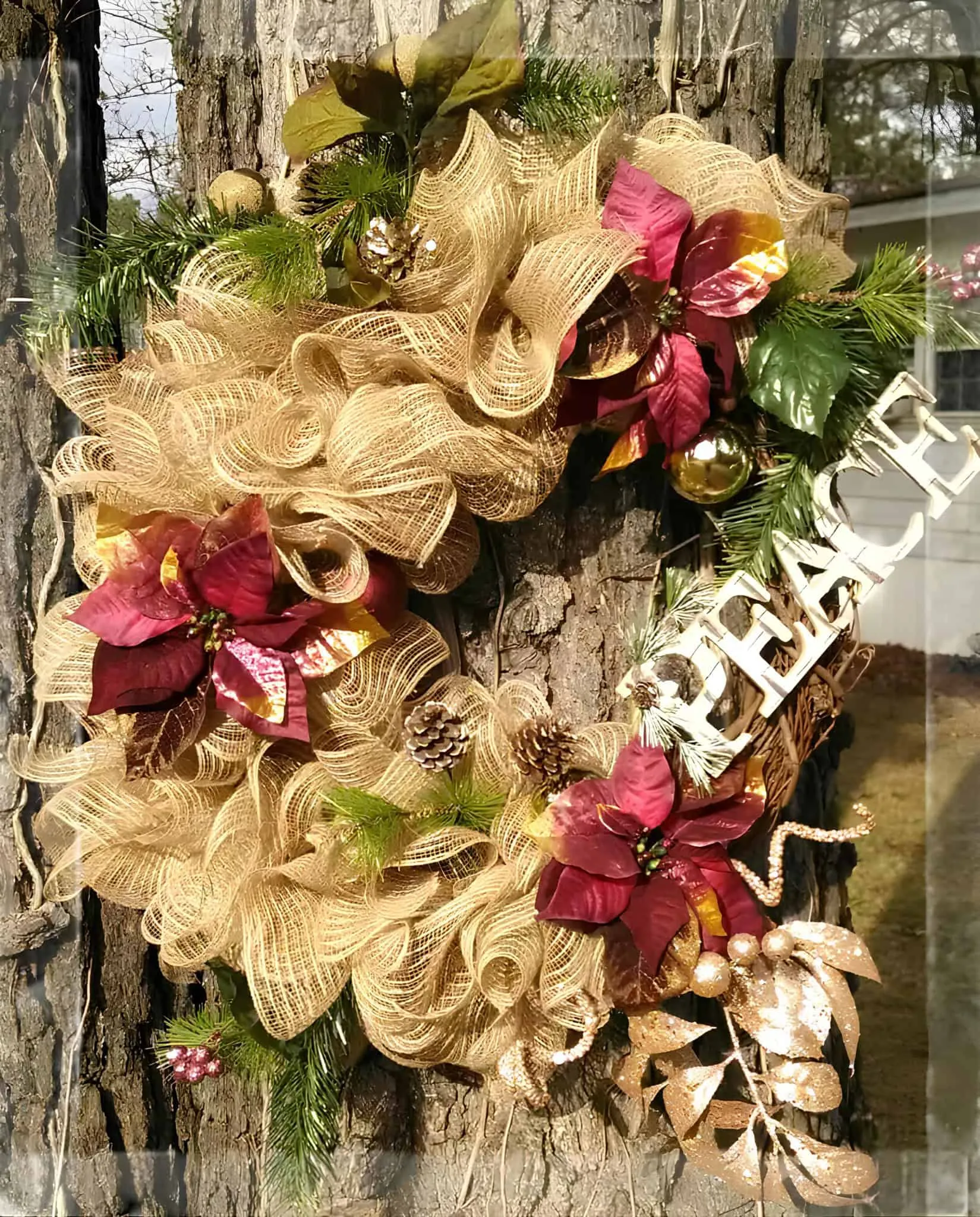 Goldene Friedens-Poinsettia-Bandkrone Goldene Bandkrone mit roten Poinsettias und einem Friedenszeichen als Akzent