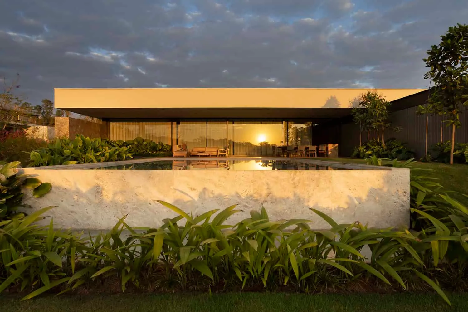 FE House Pool und Fassade bei Sonnenuntergang von N2B Arquitetura FE House von N2B Arquitetura: Pool und hintere Fassade bei Sonnenuntergang in Ribeirão Preto, Brasilien