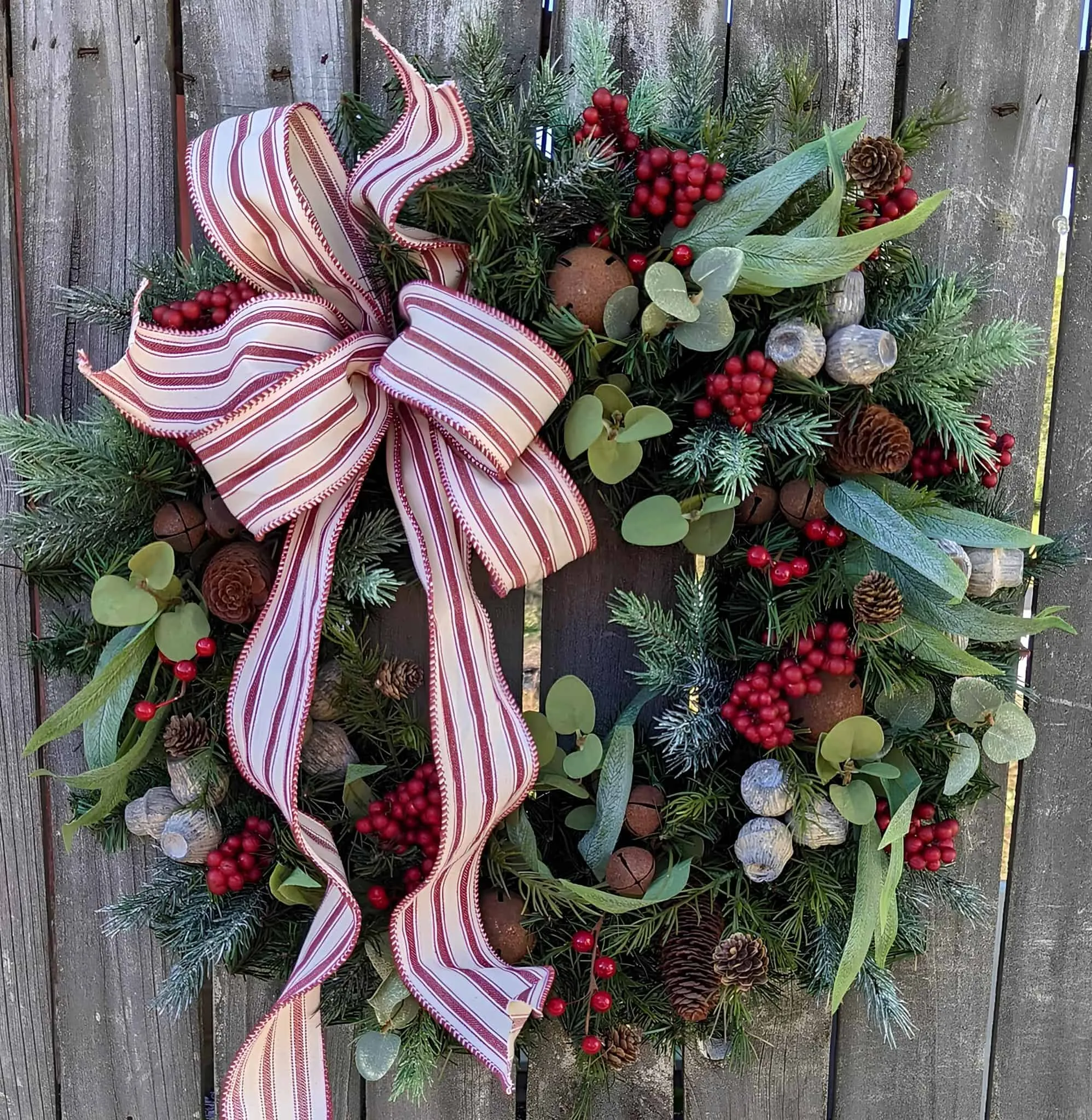 Gestreifter Schleier & Beeren – Immergrüne Weihnachtskrone Weihnachtskrone mit gestreiftem Schleier, roten Beeren, Kiefernzapfen und mit Reif überzogener Grünpflanze
