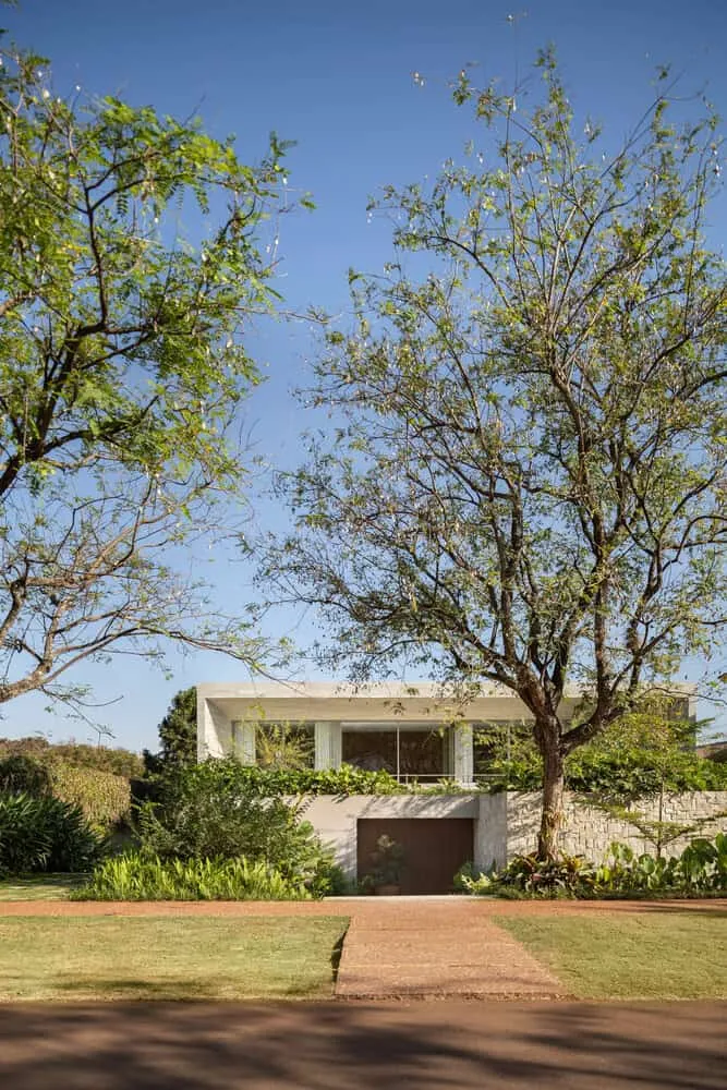Fassade des Hauses AL mit Bäumen von N2B Arquitetura Straßenfassade des Hauses AL, umrahmt von Bäumen, von N2B Arquitetura in Vila do Golfe, Brasilien