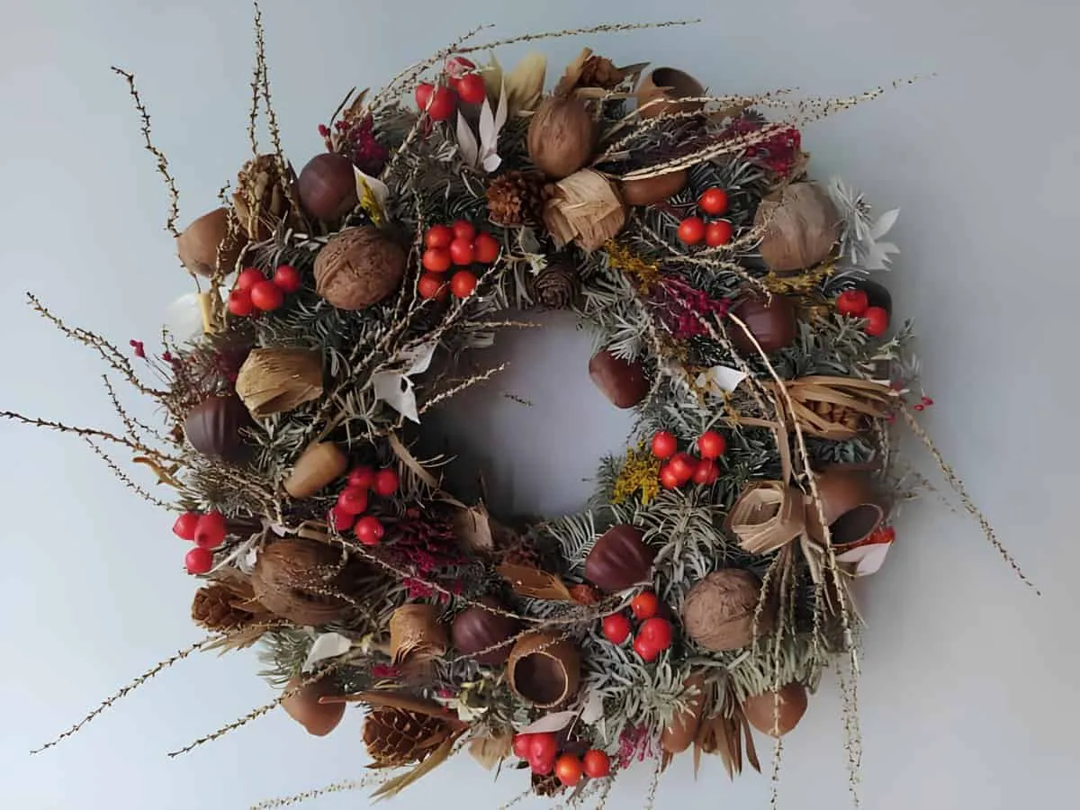 Weihnachtskranz mit rustikalen Naturakzenten Rustikaler Weihnachtskranz mit natürlichen Akzenten wie Nüssen, Kiefernzapfen und Beeren