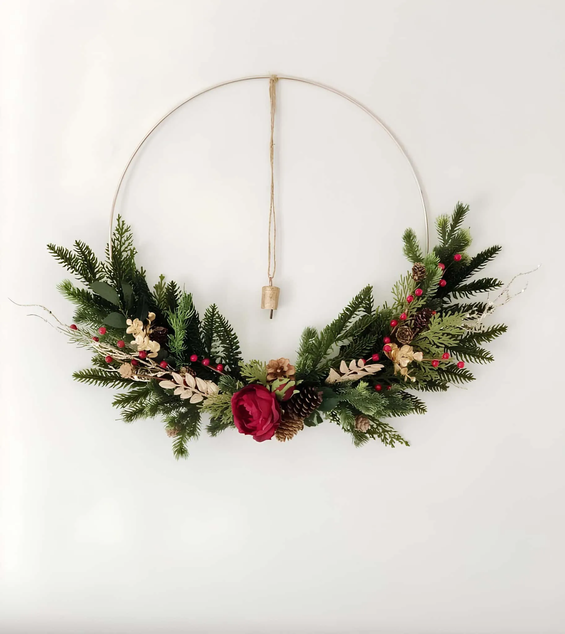 Minimaler Ringkranz mit Grünpflanzen und Rose Minimaler Metallringkranz mit Wintergrünpflanzen, Kiefernzapfen und einer einzigen roten Rose