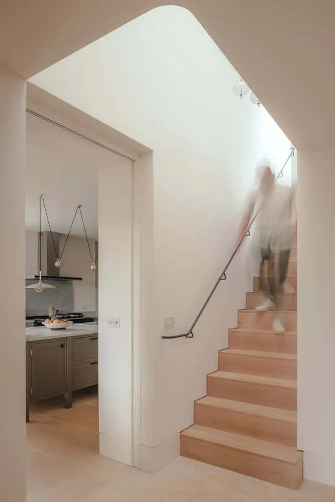 Oliver Leech Architects द्वारा डिज़ाइन किए गए Cotswolds House में मूर्तिकृत छत वाली, दिन की रोशनी में चमकती सीढ़ियाँ