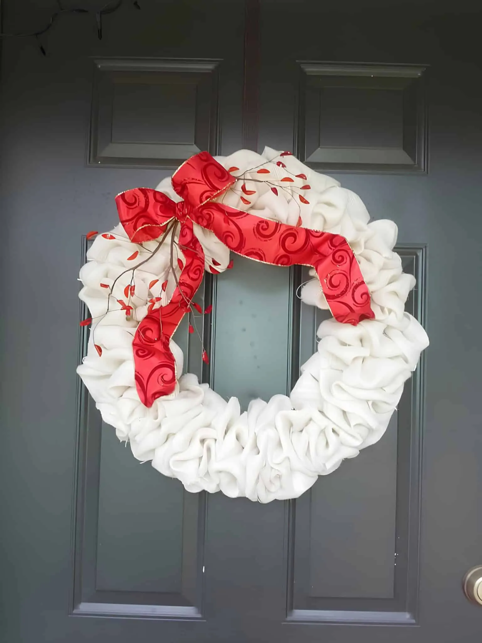 Weißer, geraffter Weihnachtskranz mit rotem Band Eleganter weißer Weihnachtskranz mit geraffter Stofftextur und einem leuchtend roten Band