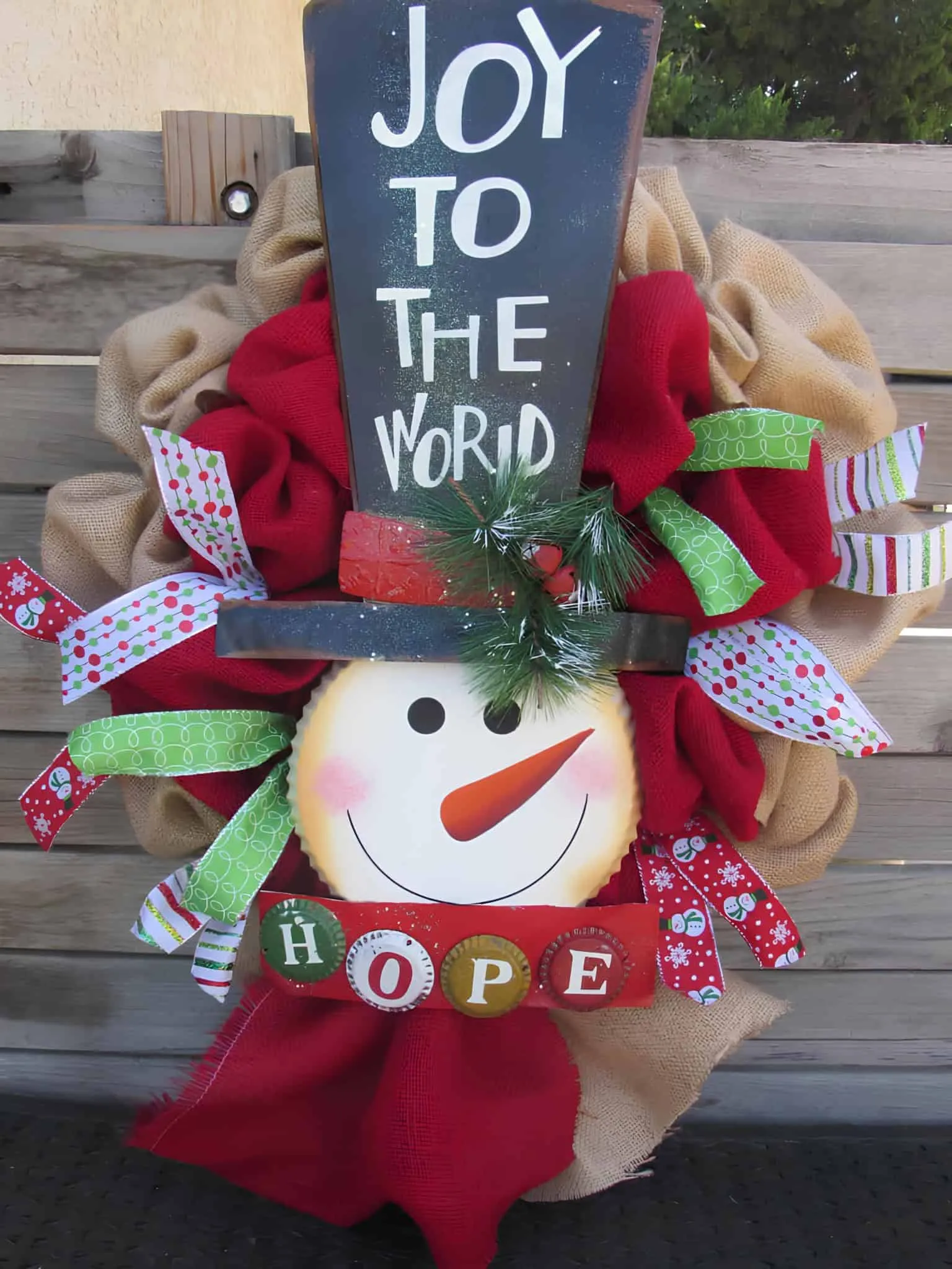 Joy to the World Snowman Wreath Weihnachtlicher Schneemannkranz mit Zylinderhut, der Aufschrift JOY TO THE WORLD und bunten Bändern