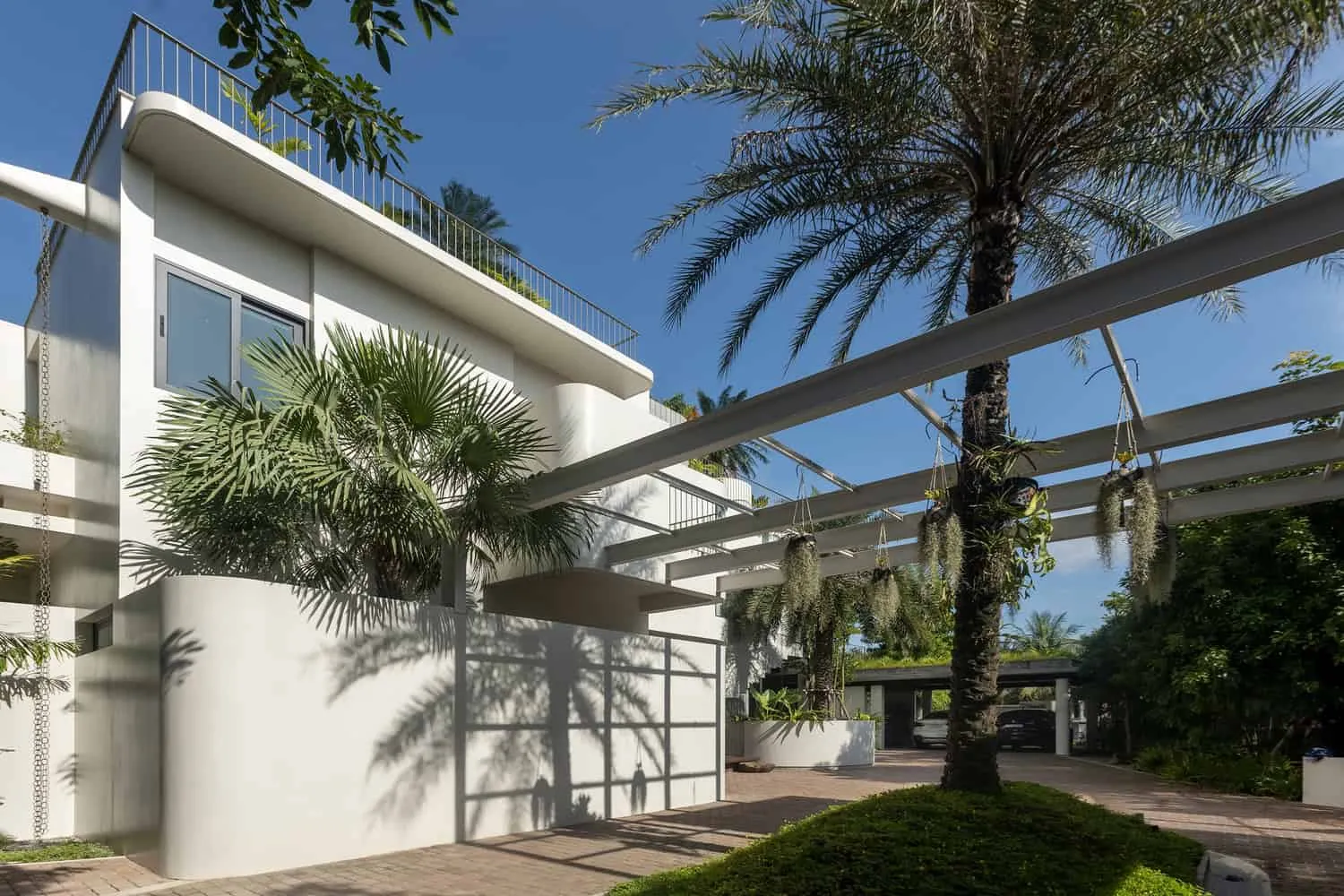Vorderfassade des Wat Bo House mit Pergola und Palmen von UAD Architects Vorderfassade des Wat Bo House von UAD Architects in Kambodscha mit Pergola und Palmen