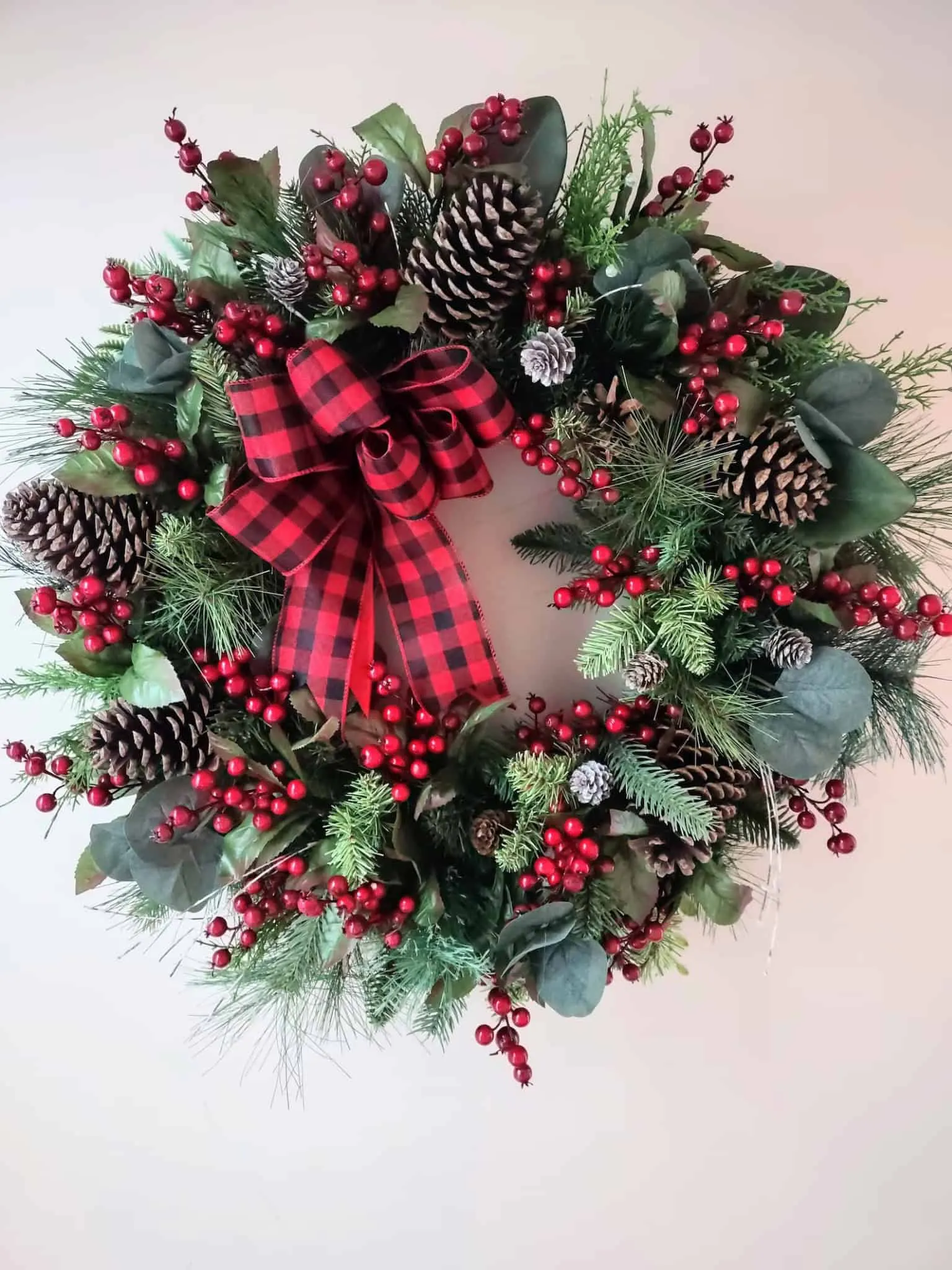 Buffalo-Plaid-Kranz mit Schleife, Kiefernzapfen und Beeren Buffalo-Plaid-Kranz mit Schleife, Kiefernzapfen und Beeren – klassischer Beerkranz zum Weihnachtsfest