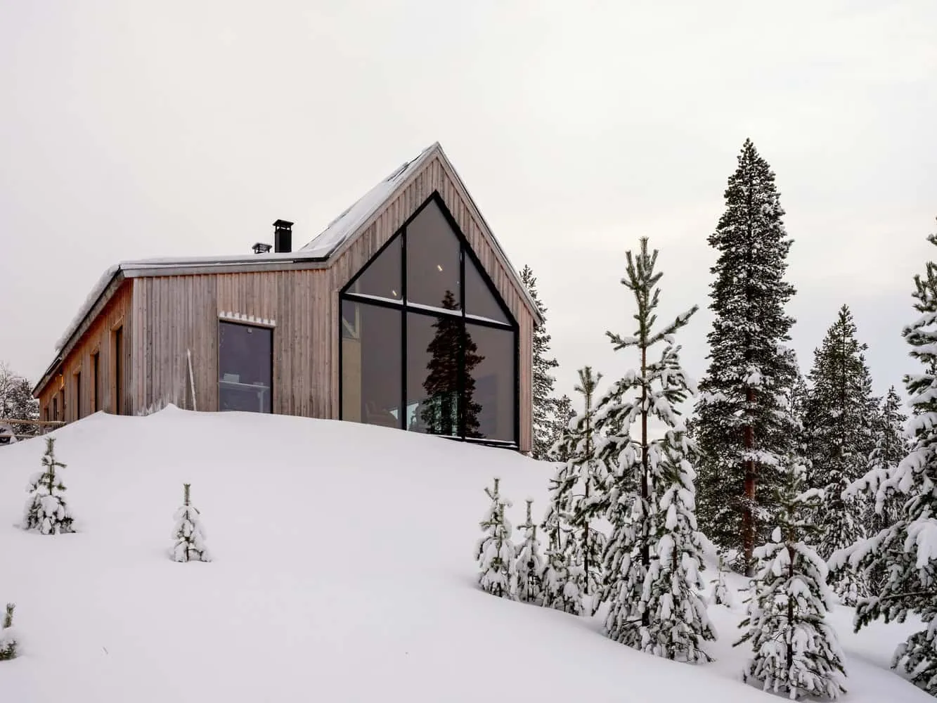 Pirinen Salo Oy设计的山丘上的房屋木结构立面 芬兰伊纳里地区积雪覆盖时的Pirinen Salo Oy设计的山丘上的房屋木结构立面