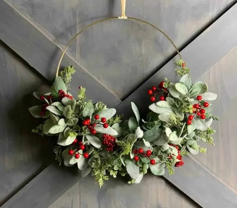 Minimalistische Krone mit Grünpflanzen und Beeren Minimalistische Weihnachtskrone mit Eukalyptusblättern und roten Beeren