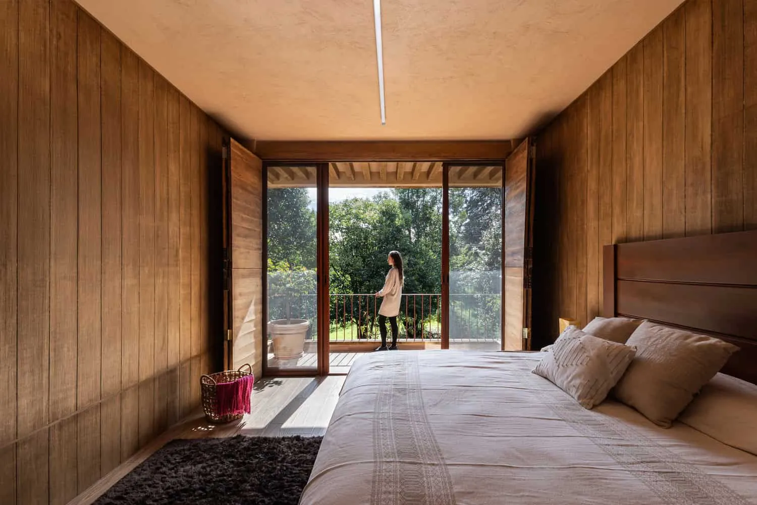 Valdez Arquitectos द्वारा डिज़ाइन किया गया The Sierra House का मास्टर बेडरूम, जिसका बाल्कनी से मेक्सिको के चियापास में स्थित हरे-भरे बगीचे का नज़ारा है