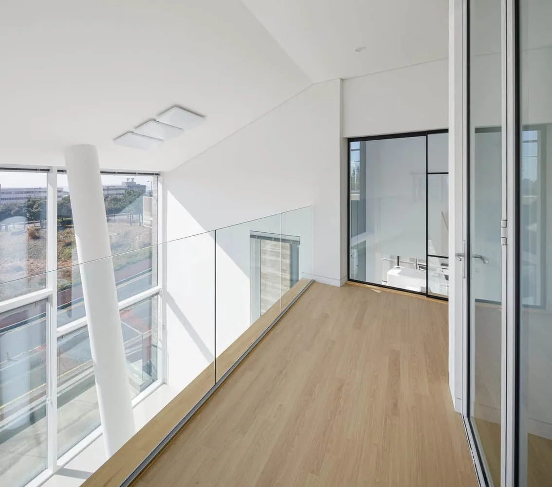 Pacific Residence Upper Glass Gallery Corridor by Moon Hoon Heller, moderner Balkon mit Glasgeländern, großen Fenstern und minimalistischem Design. Ideal für zeitgenössische Architektur und anspruchsvolle Wohnkonzepte, der innovative architektonische Elemente zeigt.