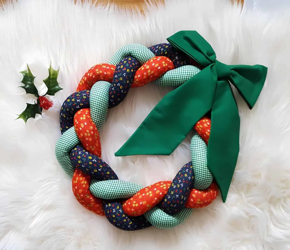Geflochtener Weihnachtskranz aus Stoffen Geflochtener Weihnachtskranz aus bunten Stoffen mit einer großen grünen Schleife