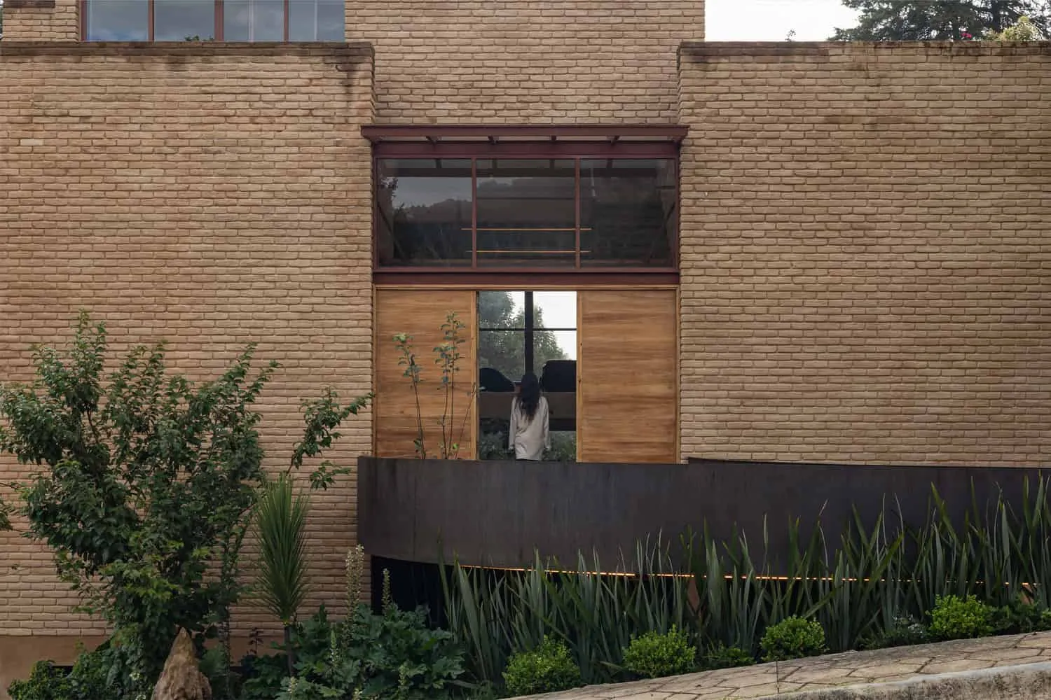 मेक्सिको के चियापास में Valdez Arquitectos द्वारा डिज़ाइन किया गया The Sierra House के प्रवेश द्वार की बालकनी एवं खिसकने वाले लकड़ी के दरवाज़ों का विवरण