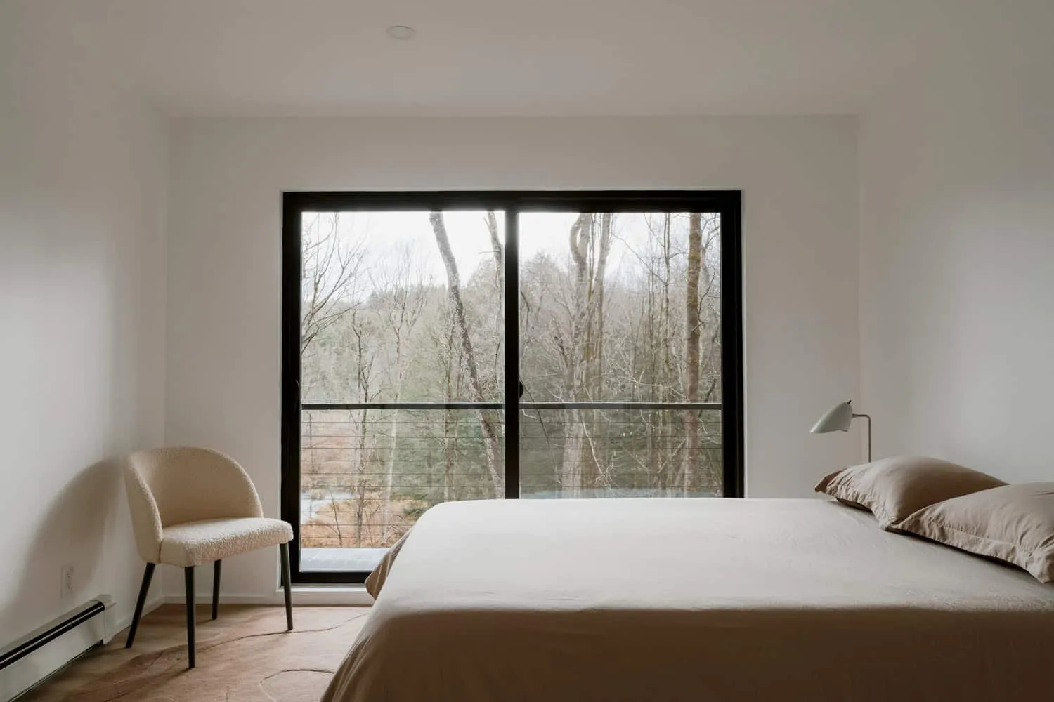 Schlafzimmer im Forest Edge House mit Blick ins Waldgebiet, Entwurf von Marc Thorpe Minimalistisches Schlafzimmer im Forest Edge House mit großem Fenster zum Wald in New York
