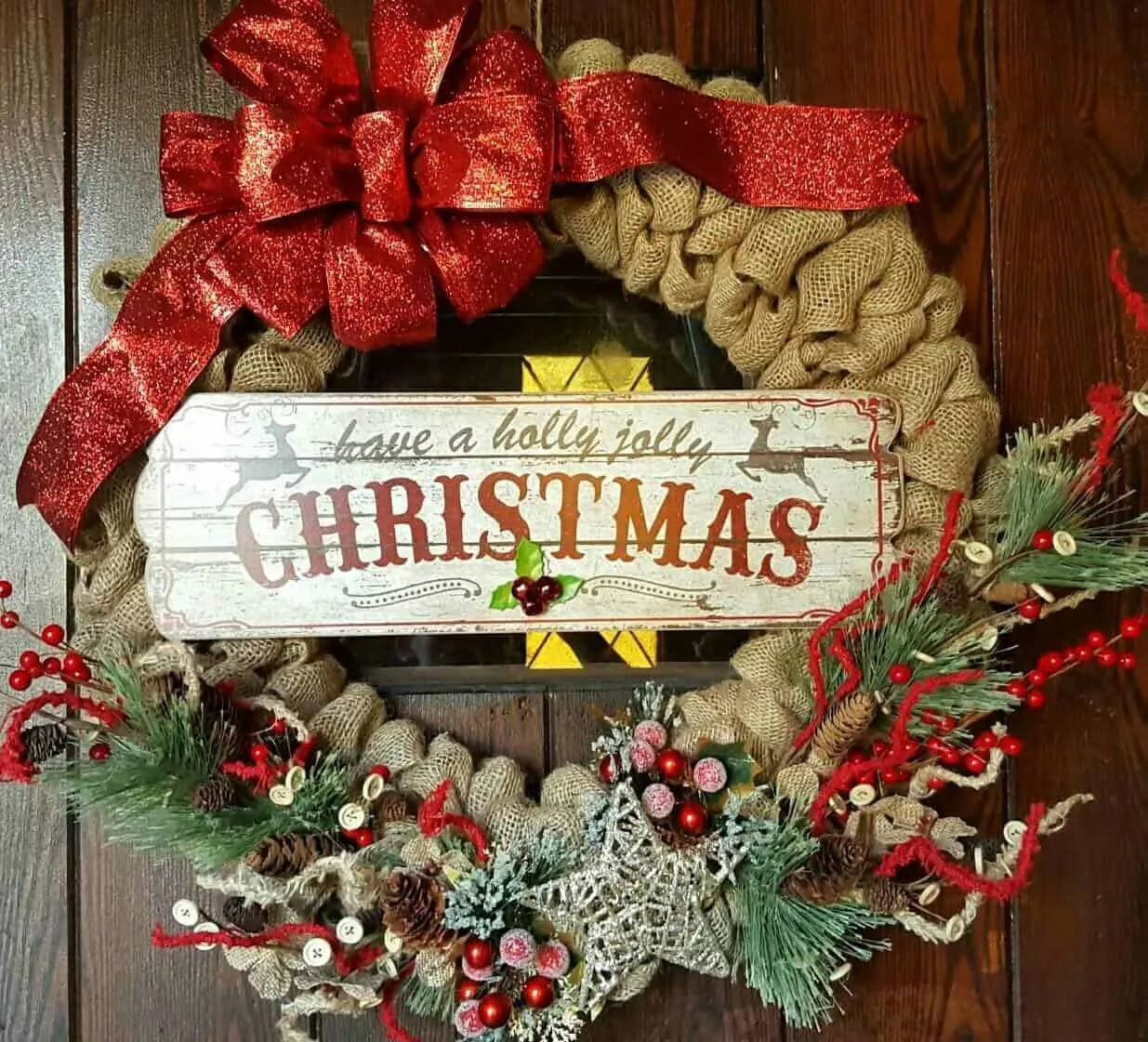 Weihnachtskranz aus Leinwand mit „Holly Jolly“-Schriftzug Weihnachtskranz aus Leinwand mit glitzernder roter Schleife und „Holly Jolly“-Schriftzug